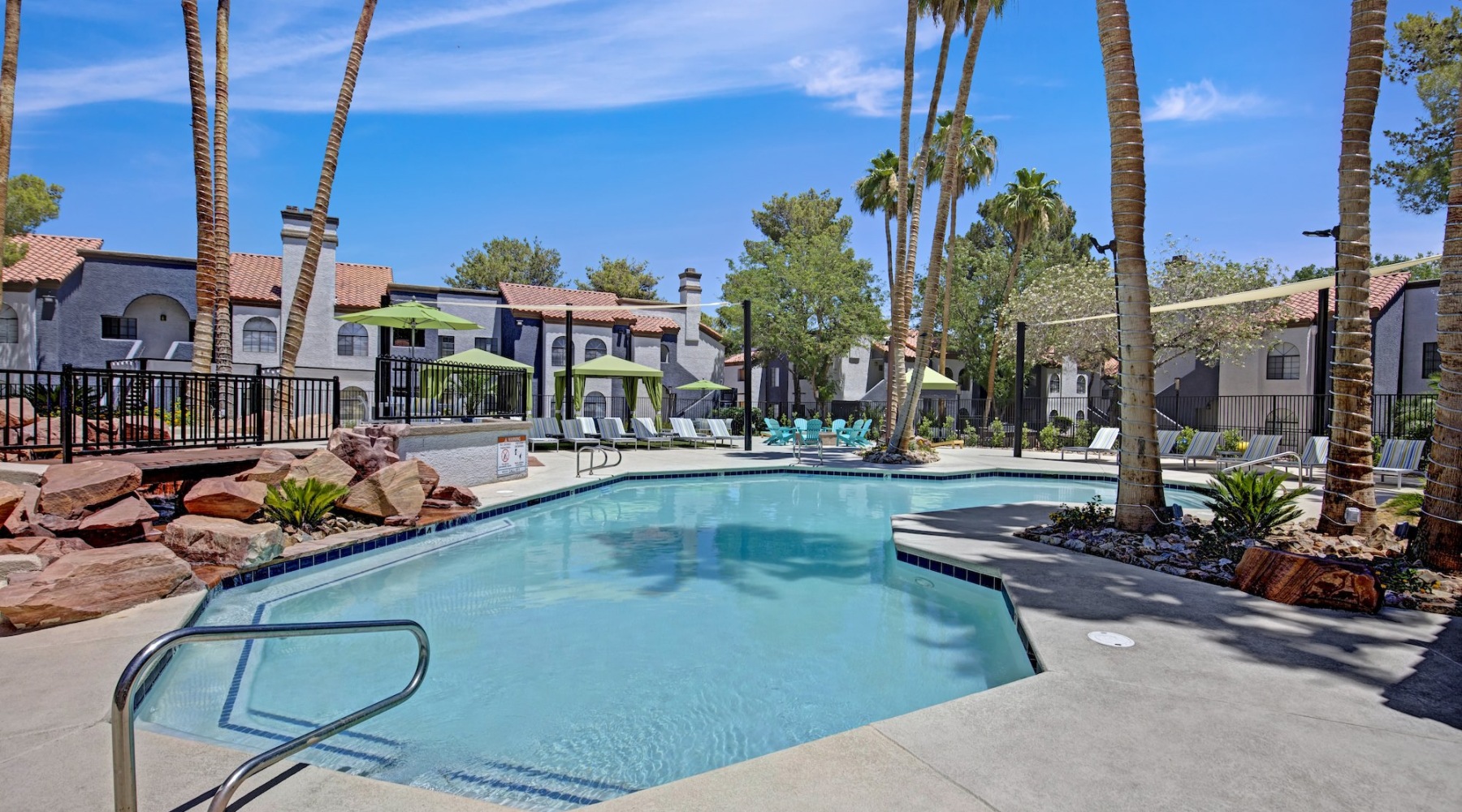 a swimming pool with palm trees and buildings in the background