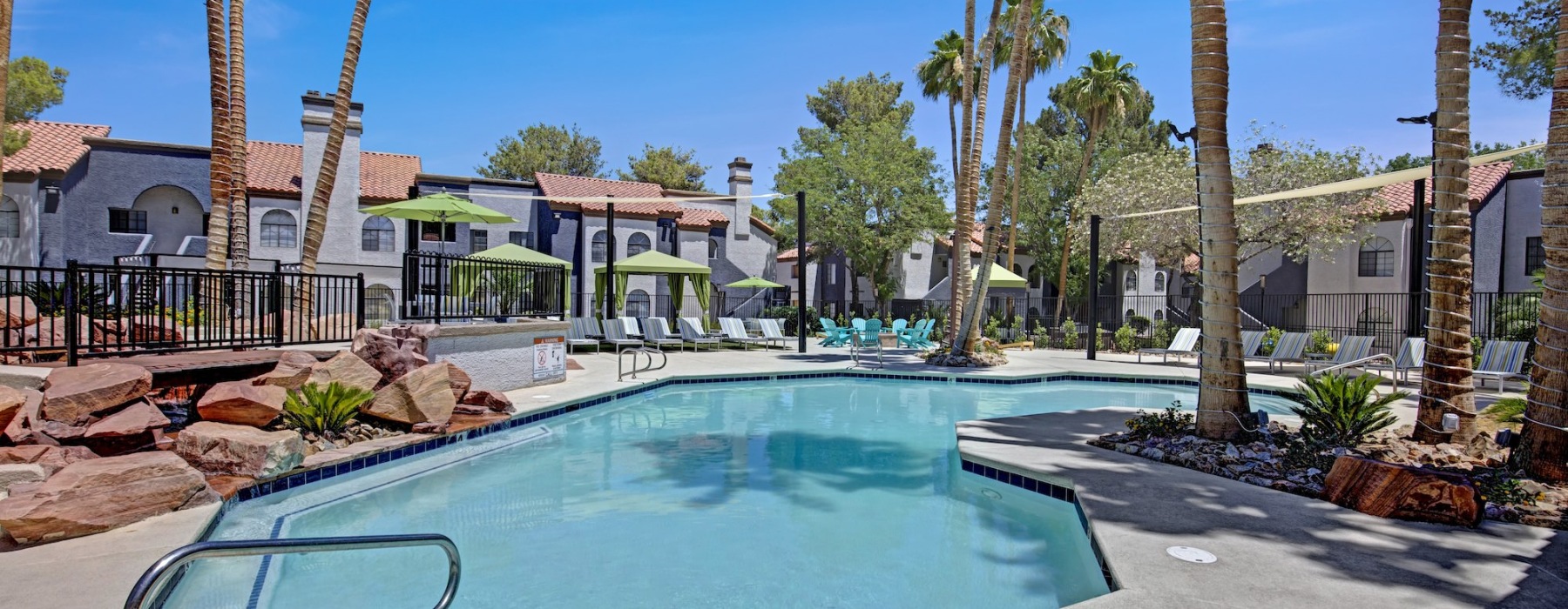 a swimming pool with palm trees and buildings in the background